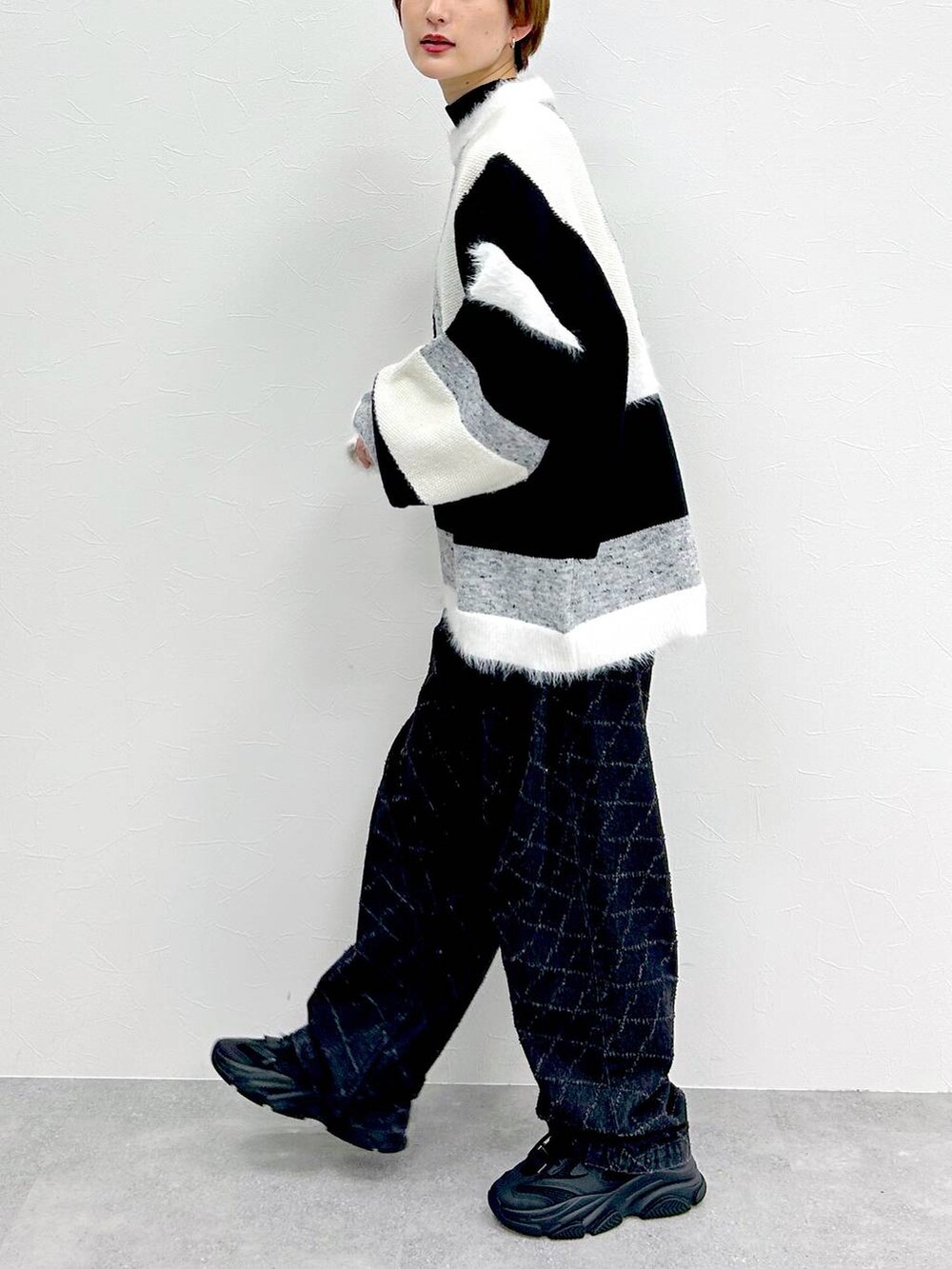 ブラック系のデニムパンツ、グレー系のニット/セーターを着用したレディースの冬コーディネートの4枚目の写真