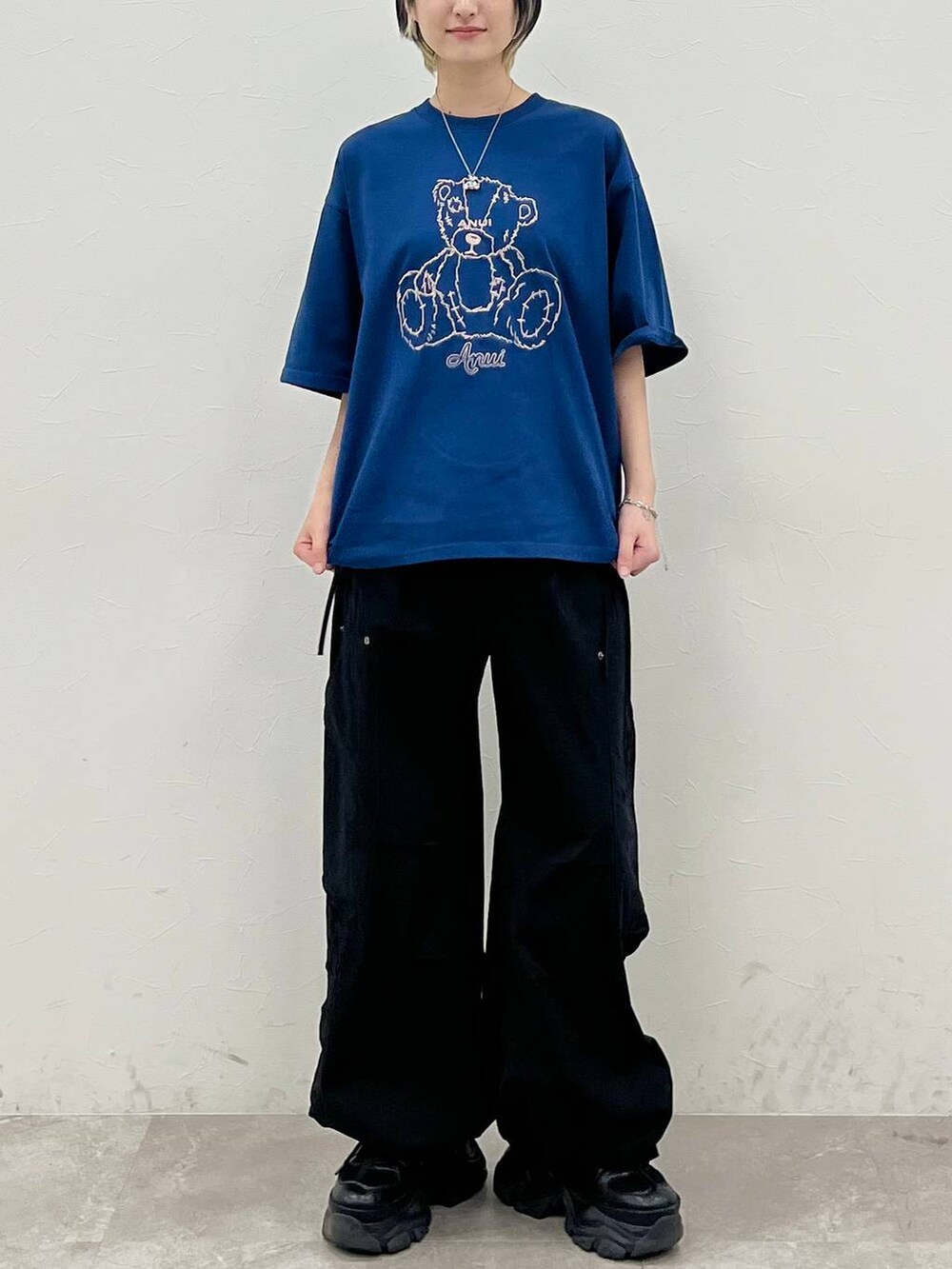 ブラック系のスニーカー、ブルー系のTシャツ/カットソー、ブラック系のカーゴパンツを着用したレディースの春コーディネートの2枚目の写真