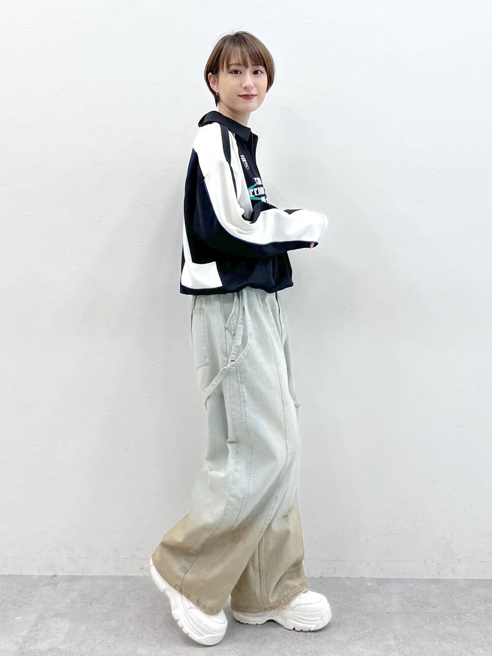 ブラック系のポロシャツ、ブルー系のデニムパンツを着用したレディースの春コーディネートの4枚目の写真