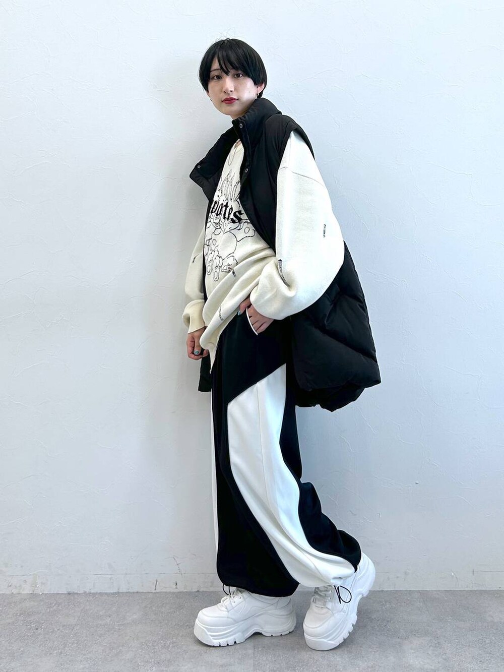 ブラック系のブルゾン、ブラック系のその他パンツ、ホワイト系のニット/セーターを着用したレディースの秋コーディネートの5枚目の写真