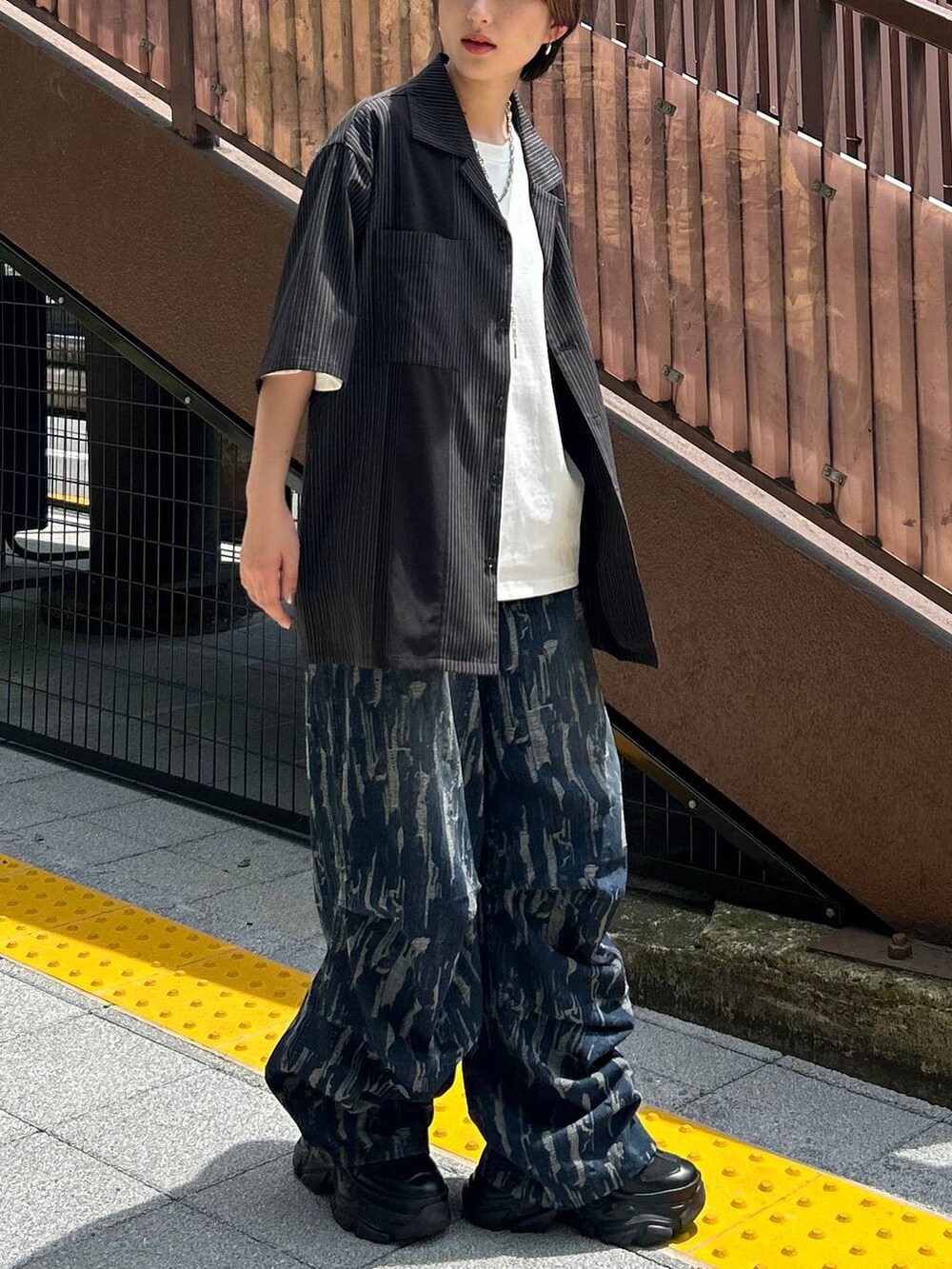 ブラック系のスニーカー、ホワイト系のTシャツ/カットソー、ブラック系のシャツ/ブラウスを着用したレディースの秋コーディネートの7枚目の写真