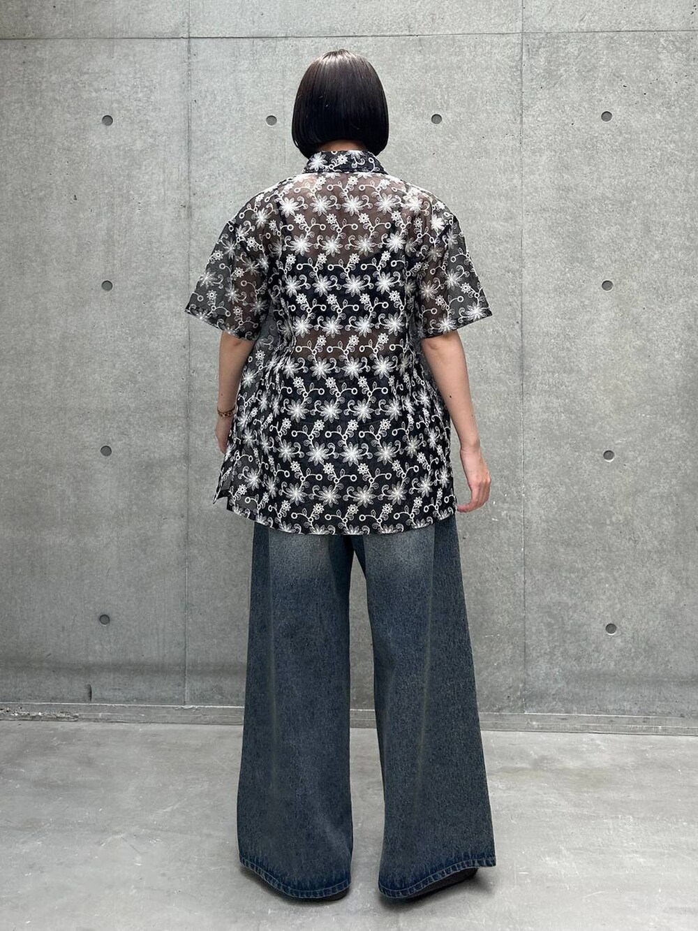 ブルー系のデニムパンツ、ブラック系のスニーカー、ブラック系のキャミソールを着用したレディースの夏コーディネートの4枚目の写真