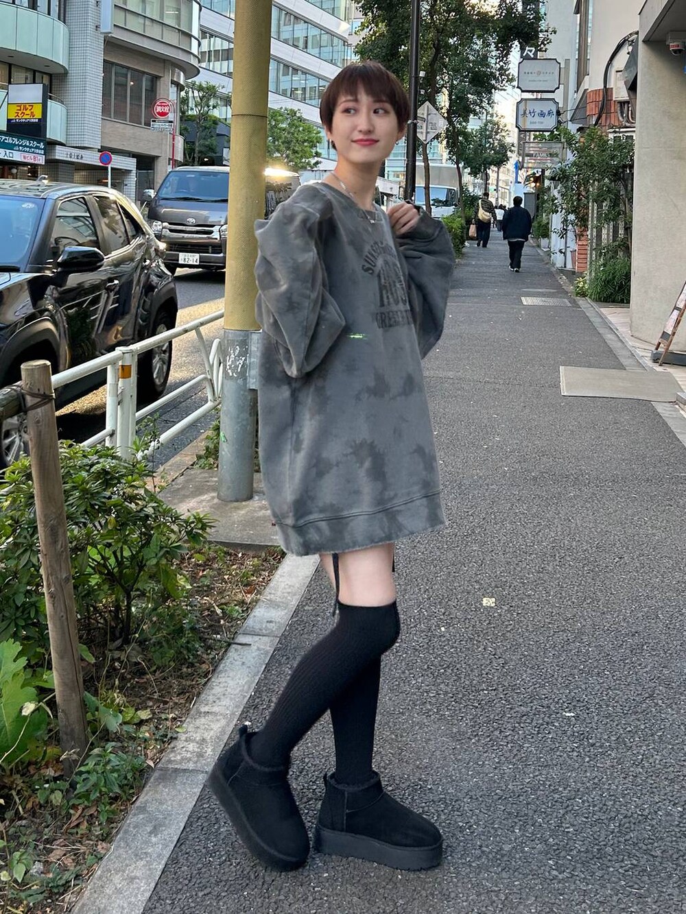 ブラック系のブーツ、ブラック系のスカート、グレー系のスウェットを着用したレディースの冬コーディネートの2枚目の写真