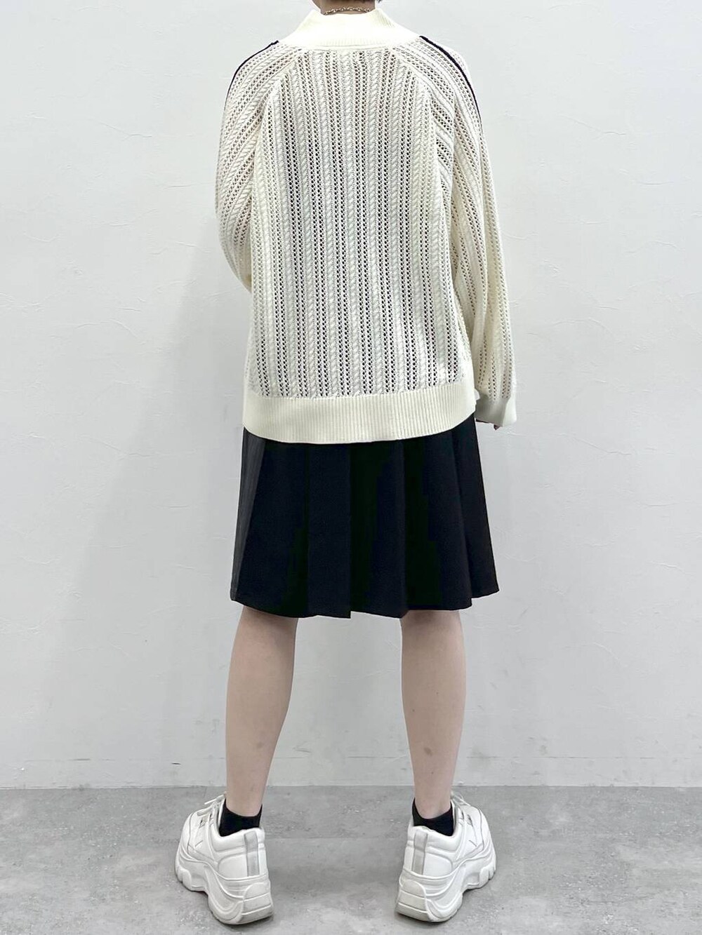 ブラック系のスラックス、ホワイト系のカーディガン/ボレロ、シルバー系のネックレスを着用したレディースの冬コーディネートの8枚目の写真