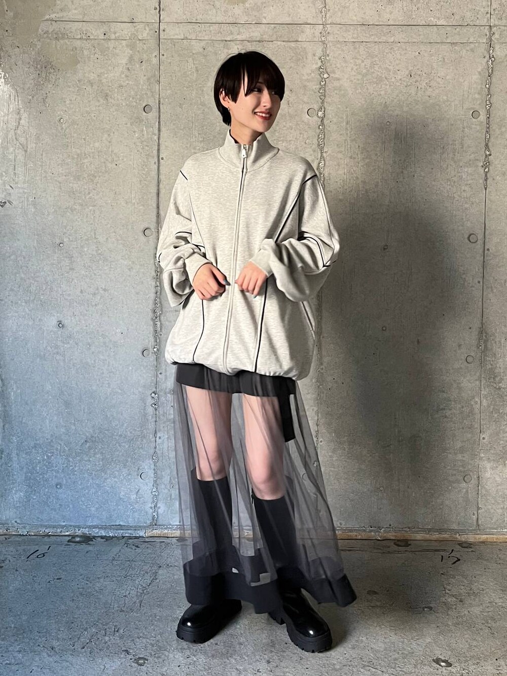 ブラック系のブーツ、グレー系のスウェット、グレー系のスカートを着用したレディースの冬コーディネートの2枚目の写真