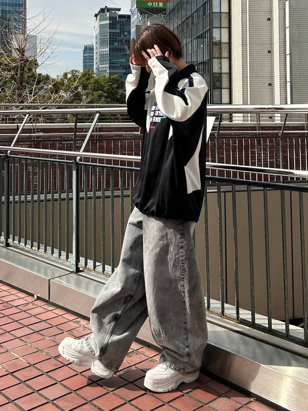 ブラック系のポロシャツ、ブラック系のデニムパンツを着用したレディースの春コーディネートの4枚目の写真