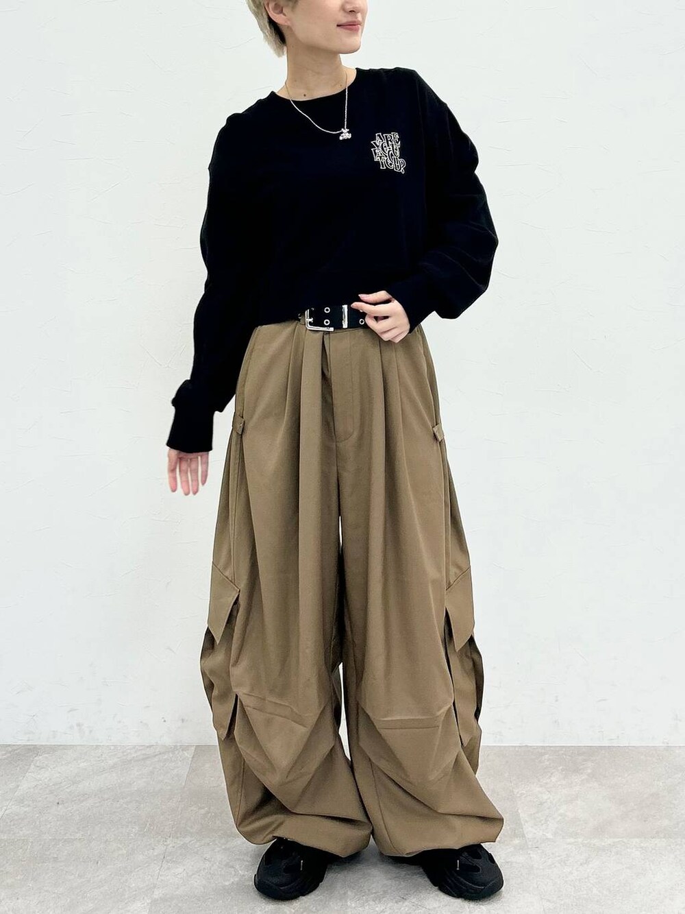 ブラック系のスウェット、ベージュ系のカーゴパンツ、シルバー系のネックレスを着用したレディースの秋コーディネートの3枚目の写真