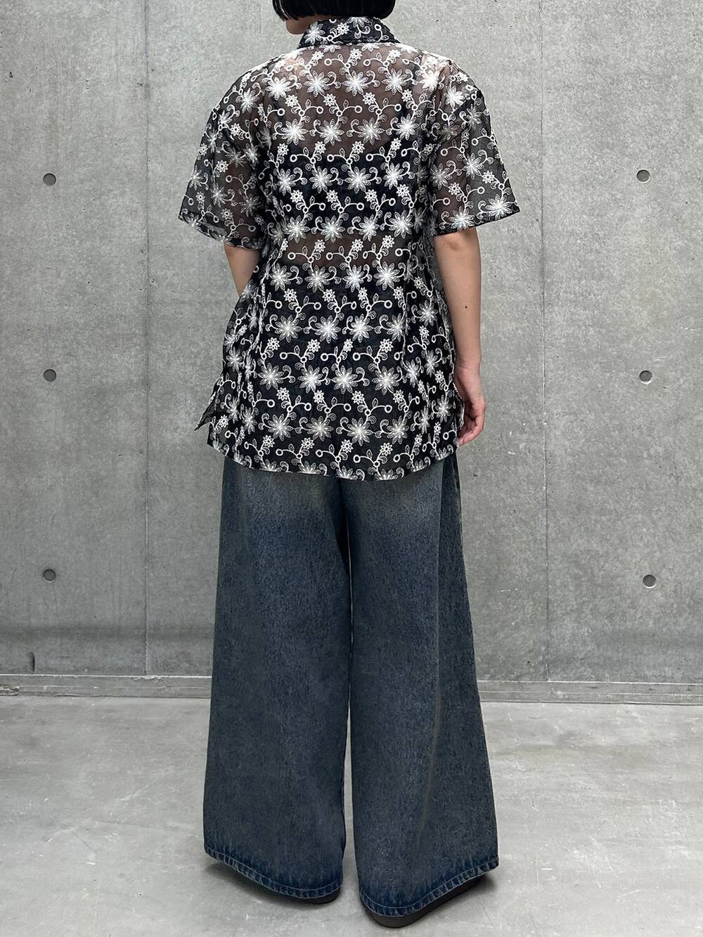 ブルー系のデニムパンツ、ブラック系のスニーカー、ブラック系のキャミソールを着用したレディースの夏コーディネートの5枚目の写真