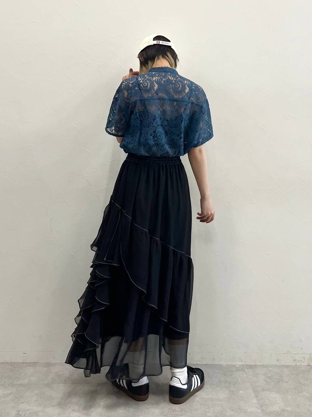 グリーン系のシャツ/ブラウス、ブラック系のスカート、ブラック系のスニーカーを着用したレディースの春コーディネートの6枚目の写真