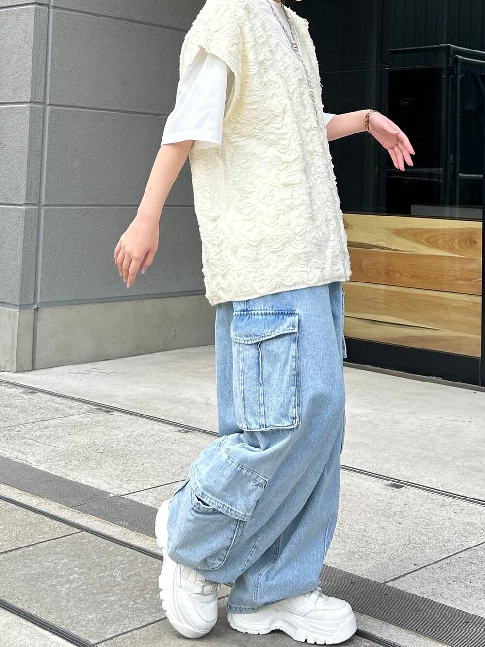 ホワイト系のベスト、ホワイト系のTシャツ/カットソー、ブルー系のデニムパンツを着用したレディースの夏コーディネートの6枚目の写真