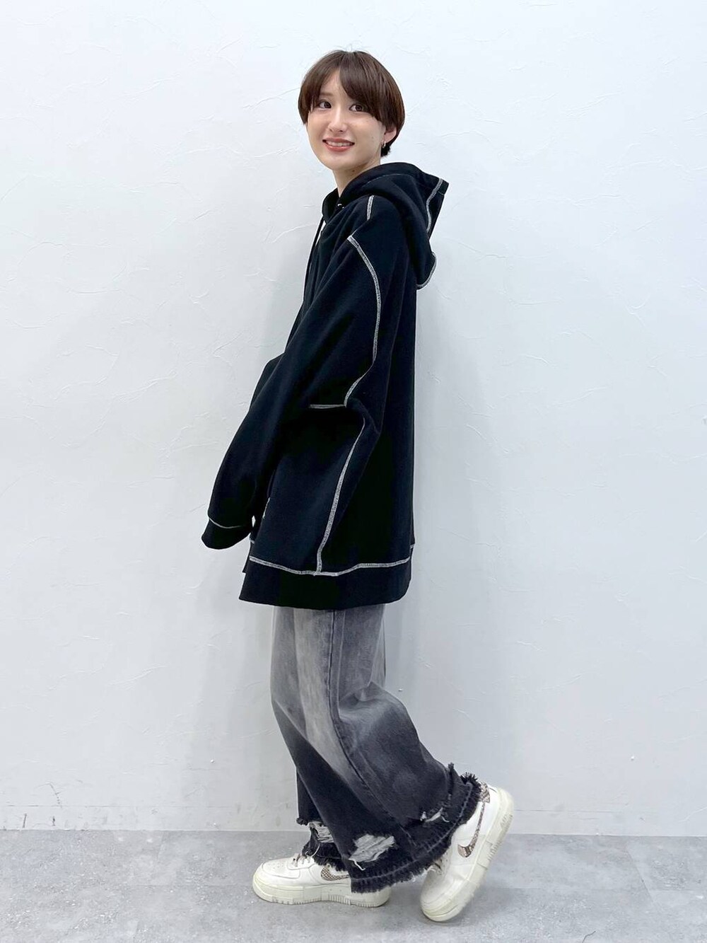 ブラック系のデニムパンツ、ブラック系のパーカーを着用したレディースの秋コーディネートの3枚目の写真