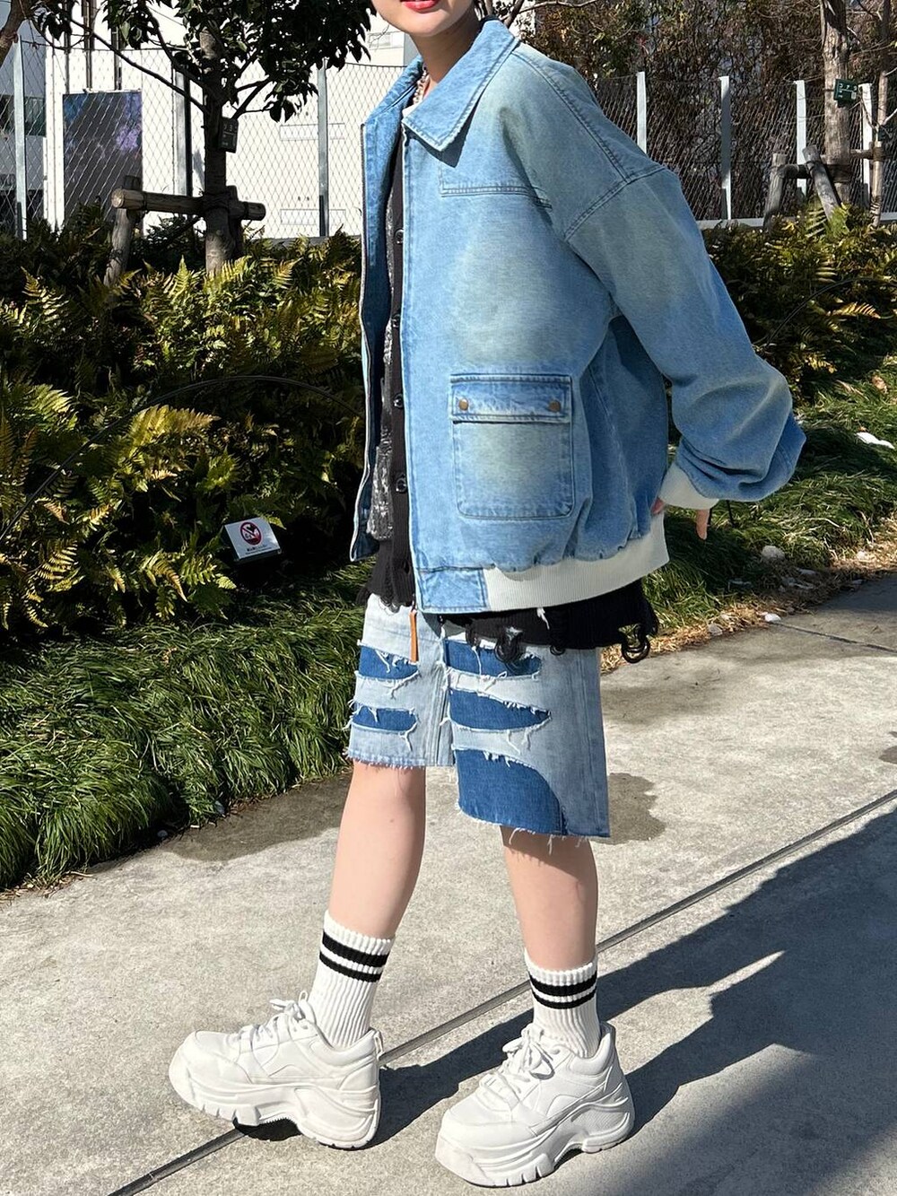 ブルー系のデニムジャケット、ブルー系のデニムパンツ、ブラック系のカーディガン/ボレロを着用したレディースの春コーディネートの5枚目の写真