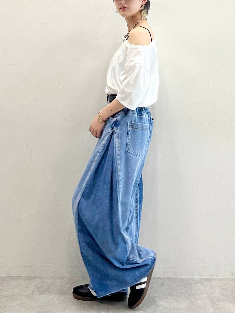 ブラック系のキャミソール、ブラック系のスニーカー、ブルー系のデニムパンツを着用したレディースの春コーディネートの4枚目の写真