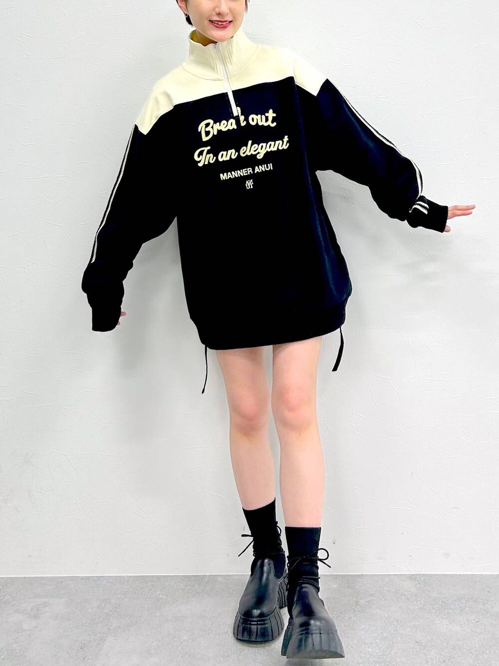 ブラック系のブーツ、ブラック系のスカート、ブラック系のスウェットを着用したレディースの冬コーディネートの2枚目の写真