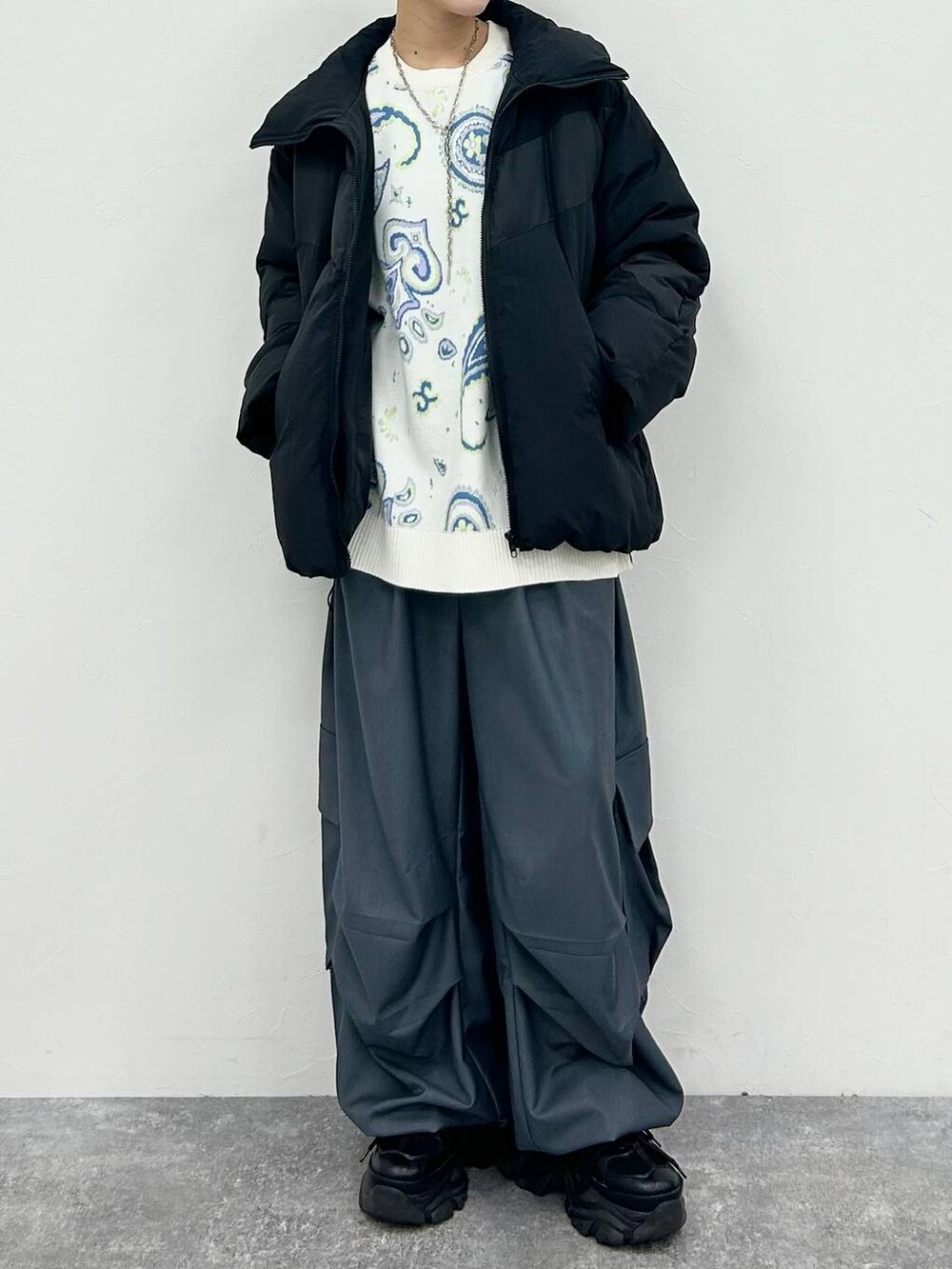 ブラック系のスニーカー、グレー系のカーゴパンツ、ブラック系のブルゾンを着用したレディースの冬コーディネートの6枚目の写真