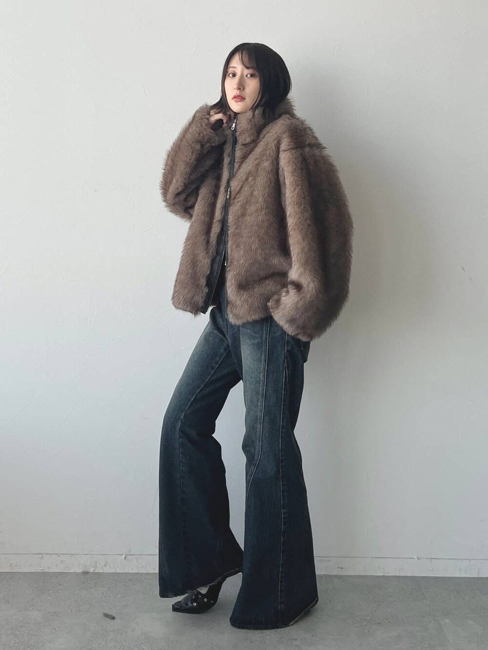 ブルー系のデニムパンツ、ブラック系のパンプスを着用したレディースの秋コーディネートの4枚目の写真