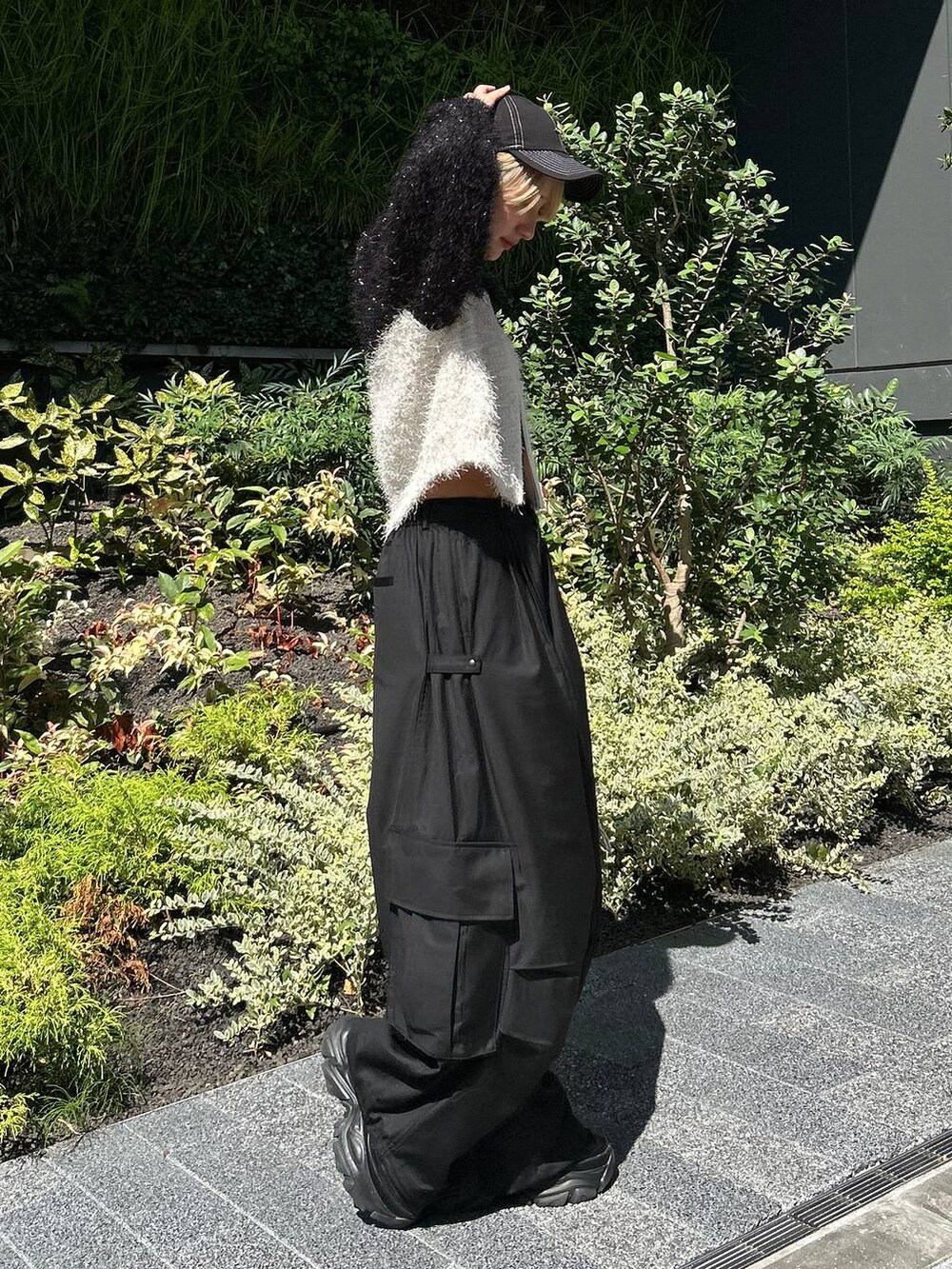 ブラック系のショルダーバッグ、ブラック系のスニーカー、ホワイト系のニット/セーターを着用したレディースの秋コーディネートの5枚目の写真