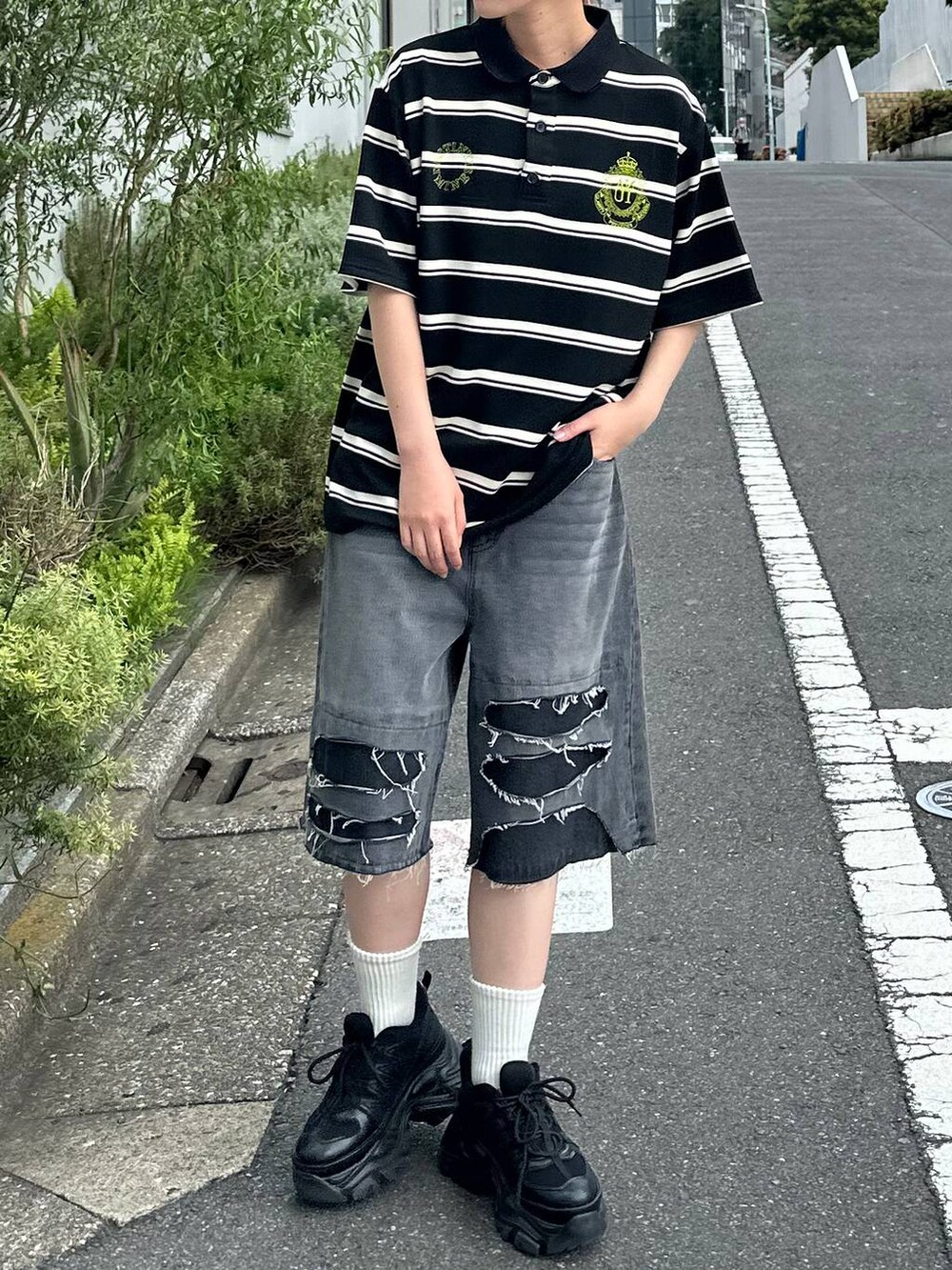 ブラック系のスニーカー、ブラック系のデニムパンツ、ブラック系のTシャツ/カットソーを着用したレディースの夏コーディネートの5枚目の写真