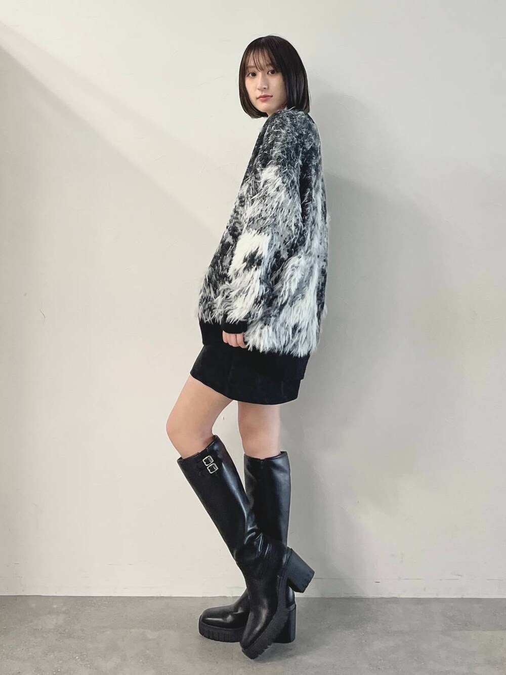 ブラック系のキャミソール、ブラック系のブーツ、ブラック系のスカートを着用したレディースの秋コーディネートの3枚目の写真