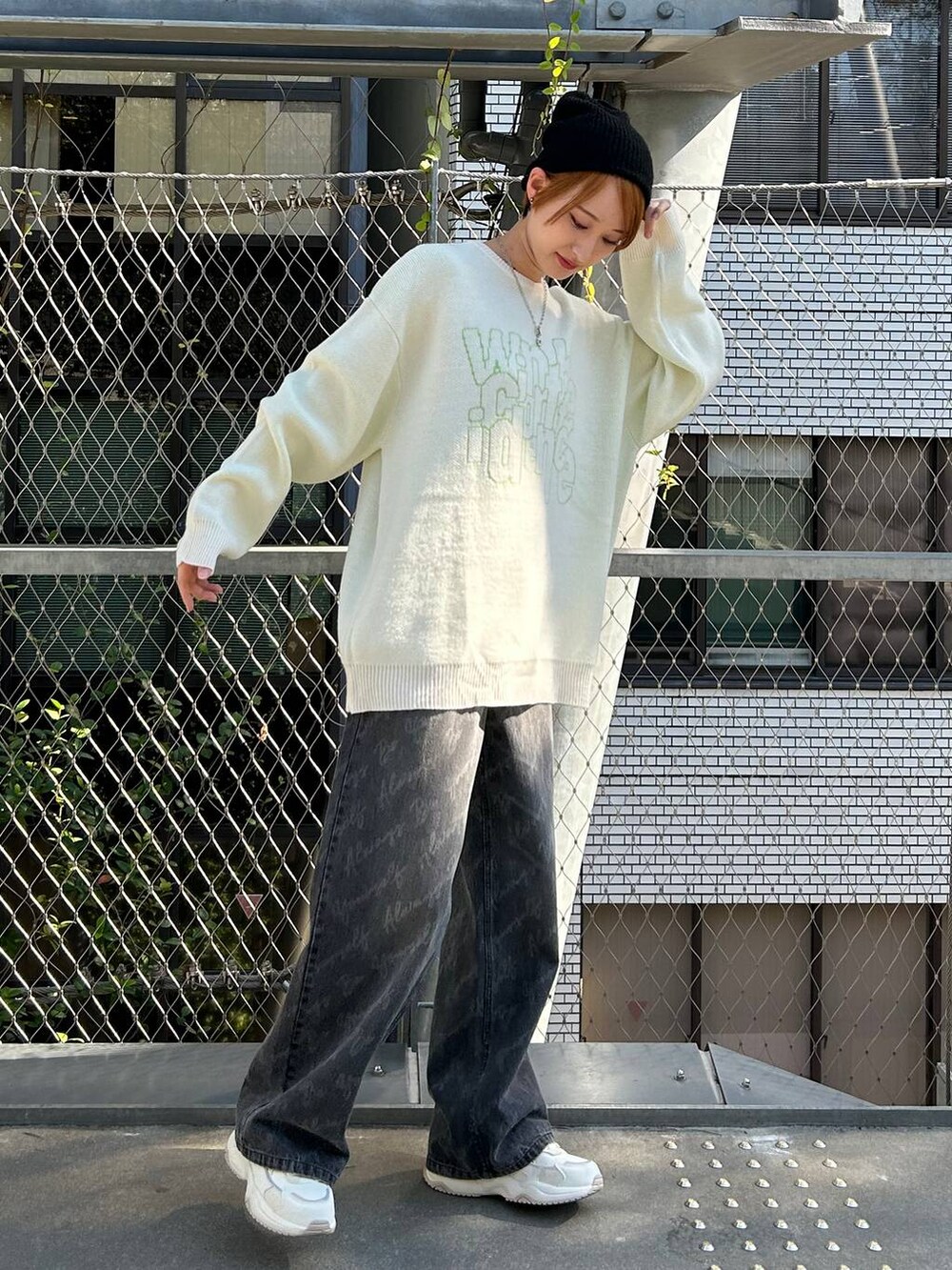 ブラック系のデニムパンツ、ホワイト系のニット/セーター、ブラック系のニットキャップ/ビーニーを着用したレディースの冬コーディネートの5枚目の写真