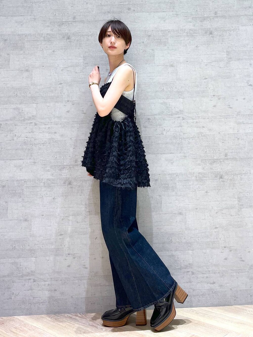 ブルー系のデニムパンツ、ブラック系のローファー、ブラウン系のショルダーバッグを着用したレディースの夏コーディネートの3枚目の写真