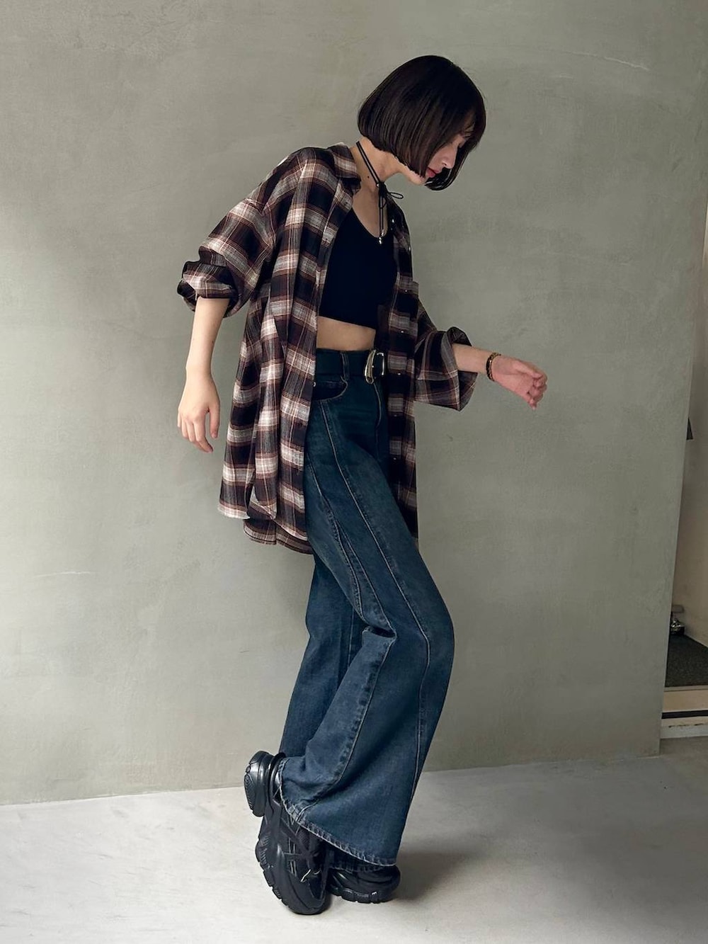 ブラック系のスニーカー、ブラック系のキャミソール、ブルー系のデニムパンツを着用したレディースの夏コーディネートの5枚目の写真