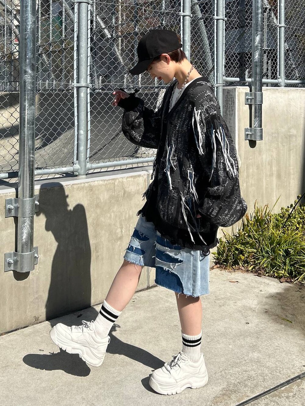 ホワイト系のTシャツ/カットソー、ブラック系のカーディガン/ボレロ、ブルー系のデニムパンツを着用したレディースの春コーディネートの3枚目の写真