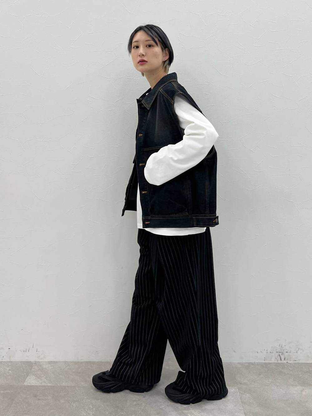 ホワイト系のTシャツ/カットソー、ブラック系のスラックス、ブラック系のデニムジャケットを着用したレディースの春コーディネートの3枚目の写真