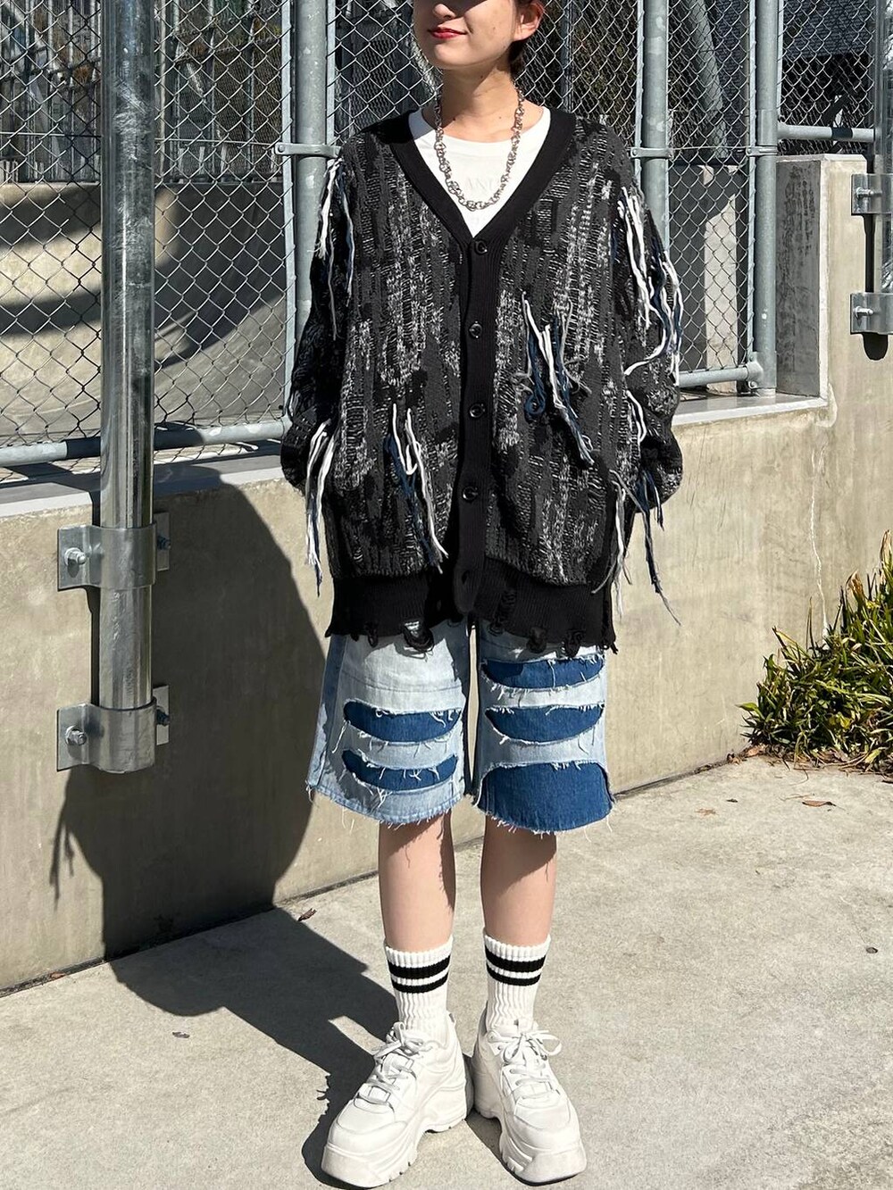 ホワイト系のTシャツ/カットソー、ブラック系のカーディガン/ボレロ、ブルー系のデニムパンツを着用したレディースの春コーディネートの2枚目の写真