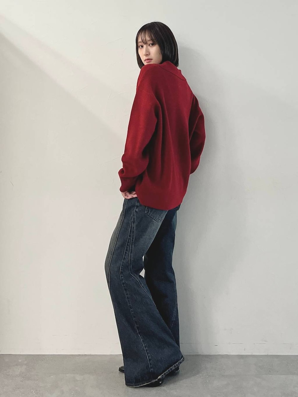 ブラック系のキャミソール、ブルー系のデニムパンツ、ブラック系のパンプスを着用したレディースの秋コーディネートの4枚目の写真