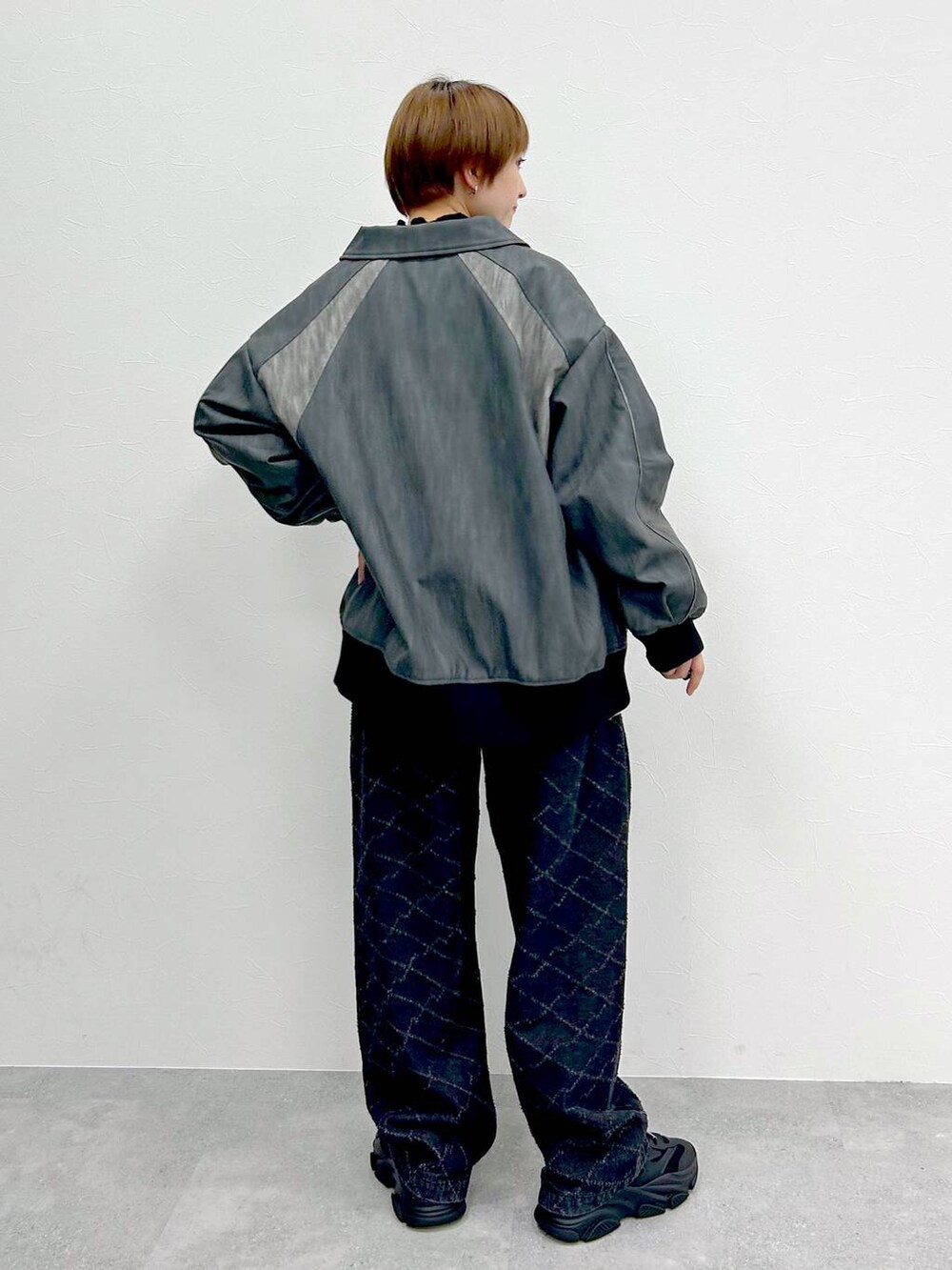 グレー系のブルゾン、ブラック系のデニムパンツ、グレー系のニット/セーターを着用したレディースの春コーディネートの7枚目の写真