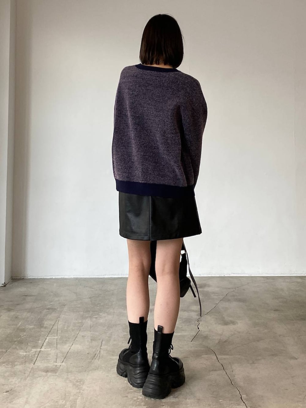 ブラック系のブーツ、ブラック系のスカート、ブラック系のショルダーバッグを着用したレディースの冬コーディネートの5枚目の写真