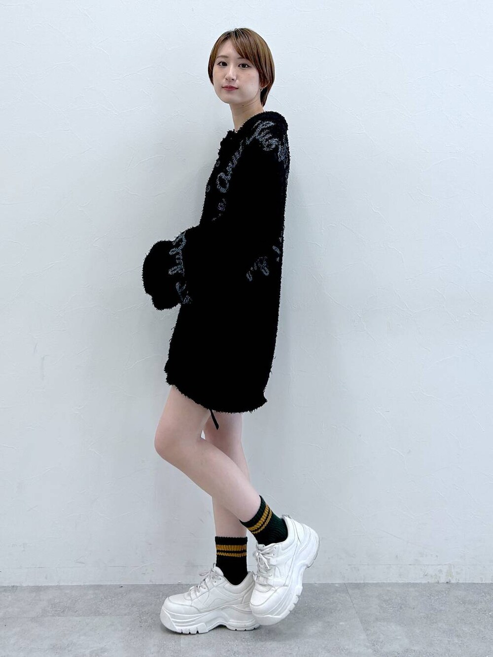 ブラック系のニット/セーターを着用したレディースの春コーディネートの6枚目の写真