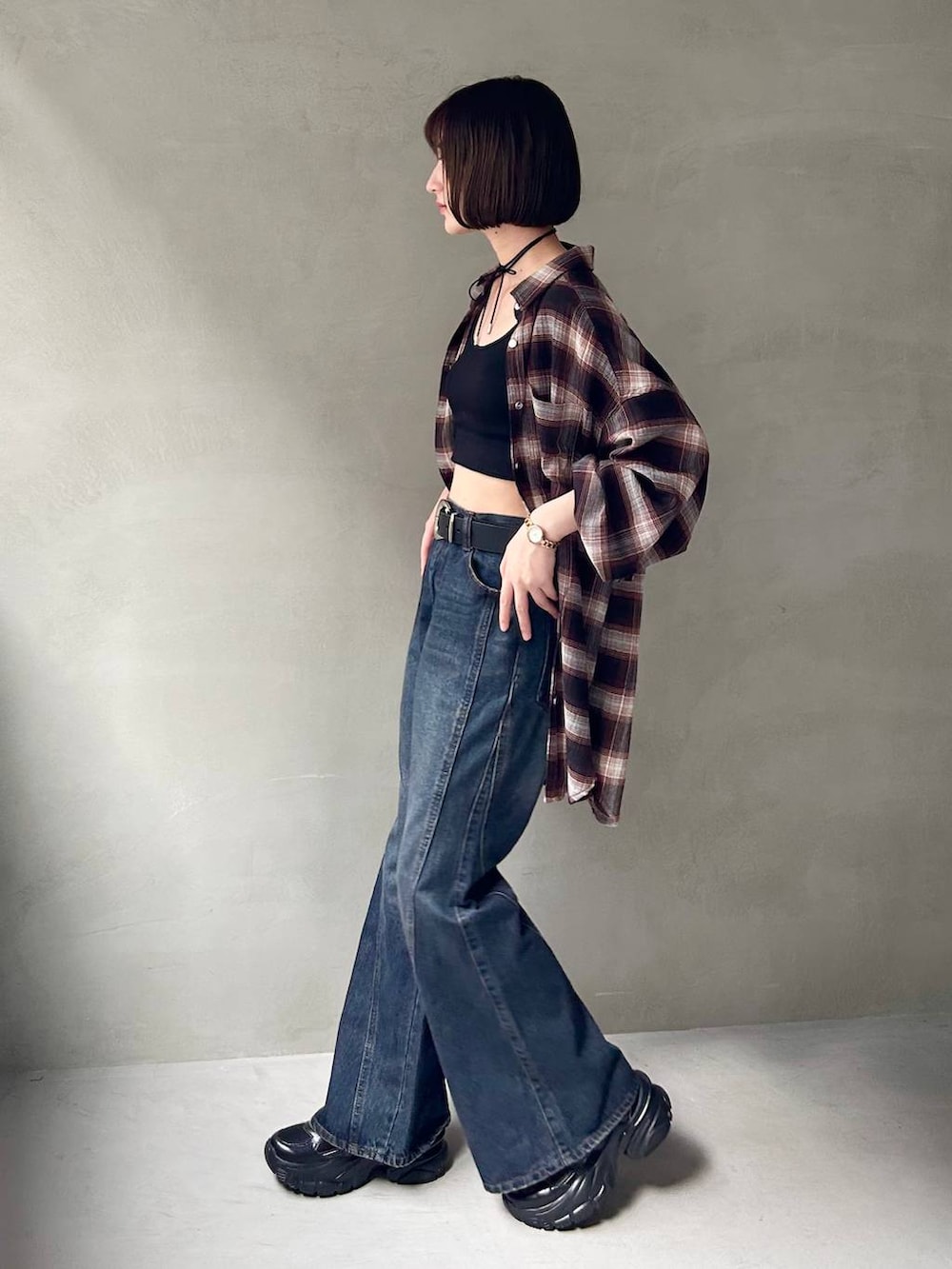 ブラック系のスニーカー、ブラック系のキャミソール、ブルー系のデニムパンツを着用したレディースの夏コーディネートの3枚目の写真