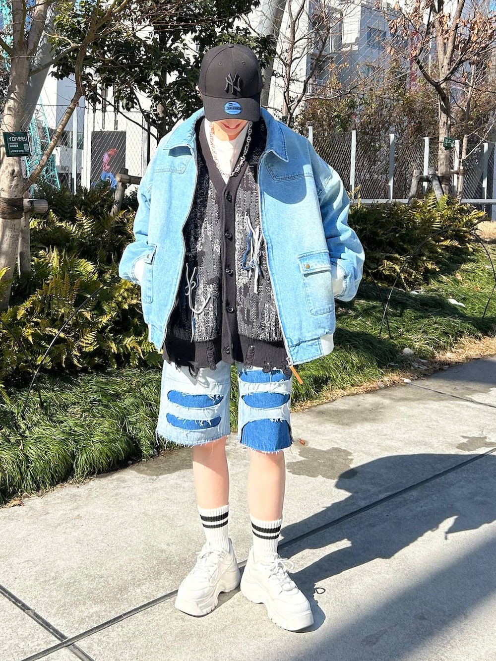 ブルー系のデニムジャケット、ブルー系のデニムパンツ、ブラック系のカーディガン/ボレロを着用したレディースの春コーディネートの2枚目の写真