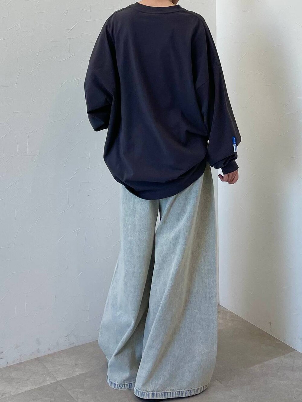 ブラック系のスニーカー、ブルー系のデニムパンツ、ブラック系のキャップを着用したレディースの春コーディネートの8枚目の写真