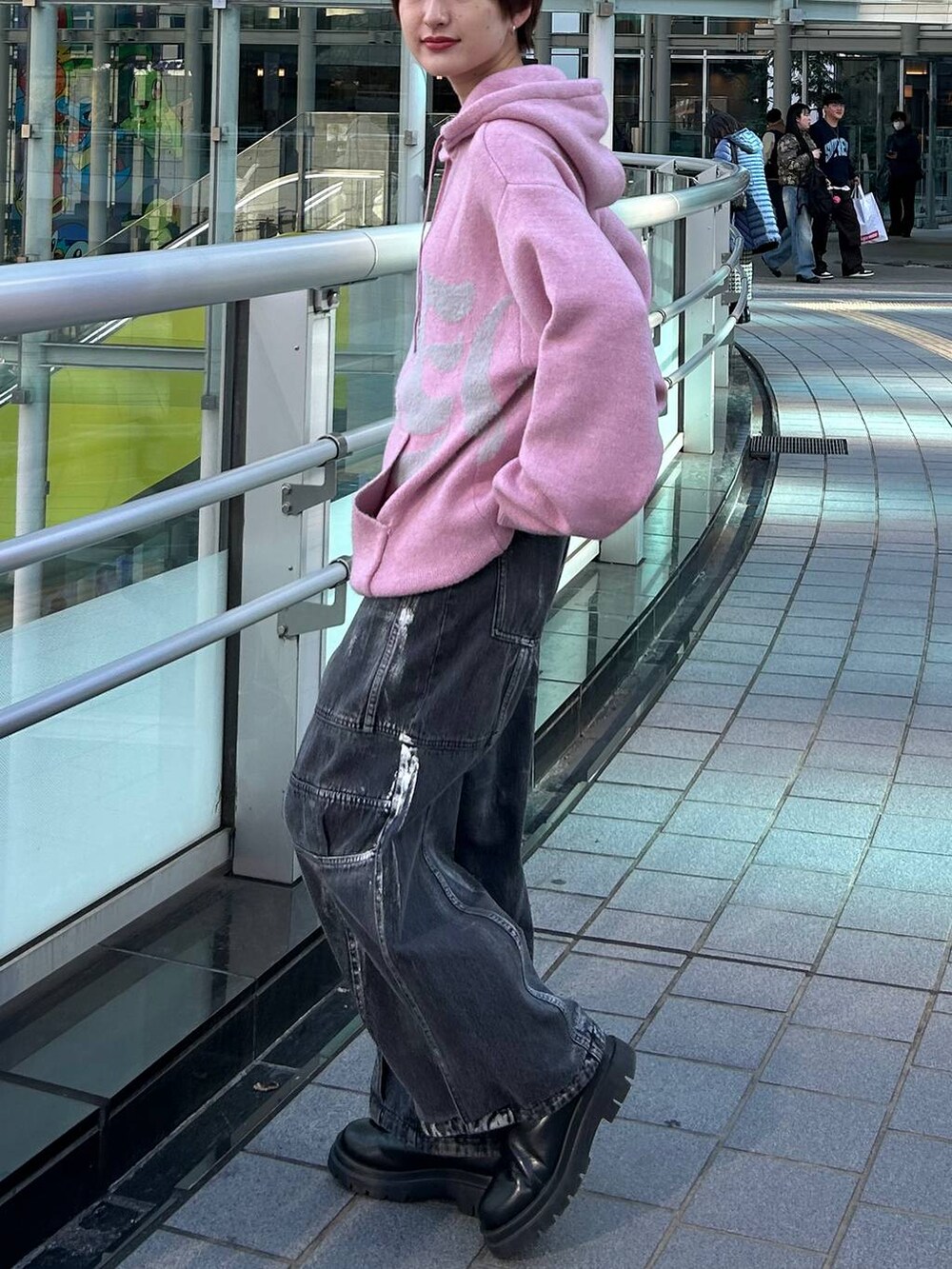 ピンク系のニット/セーター、ブラック系のデニムパンツを着用したレディースの冬コーディネートの4枚目の写真