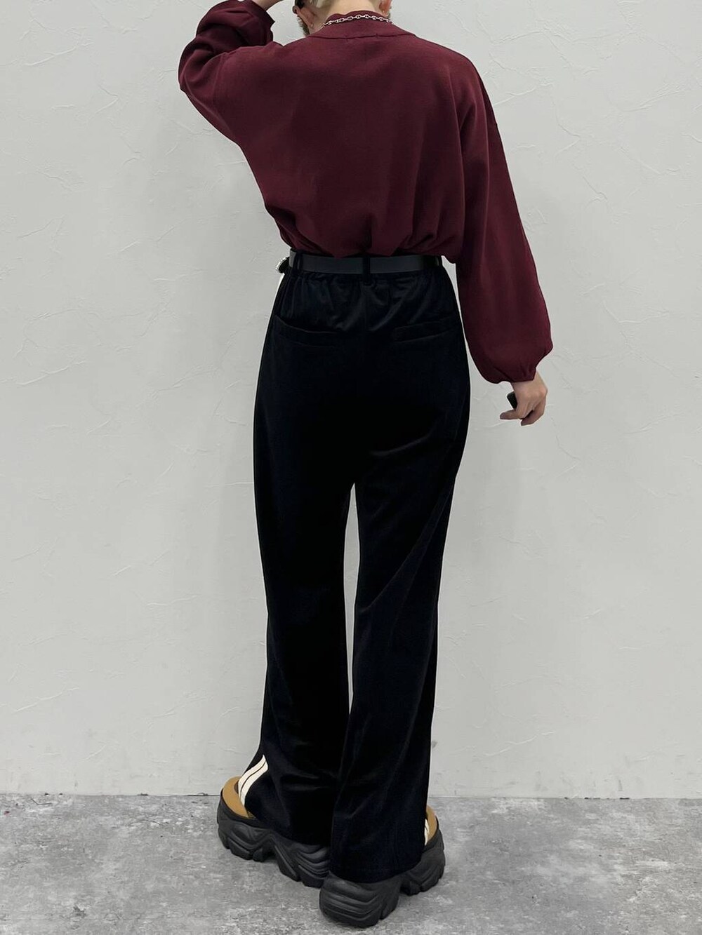 ブラウン系のブーツ、レッド系のニット/セーター、ブラック系のスウェットパンツを着用したレディースの秋コーディネートの8枚目の写真