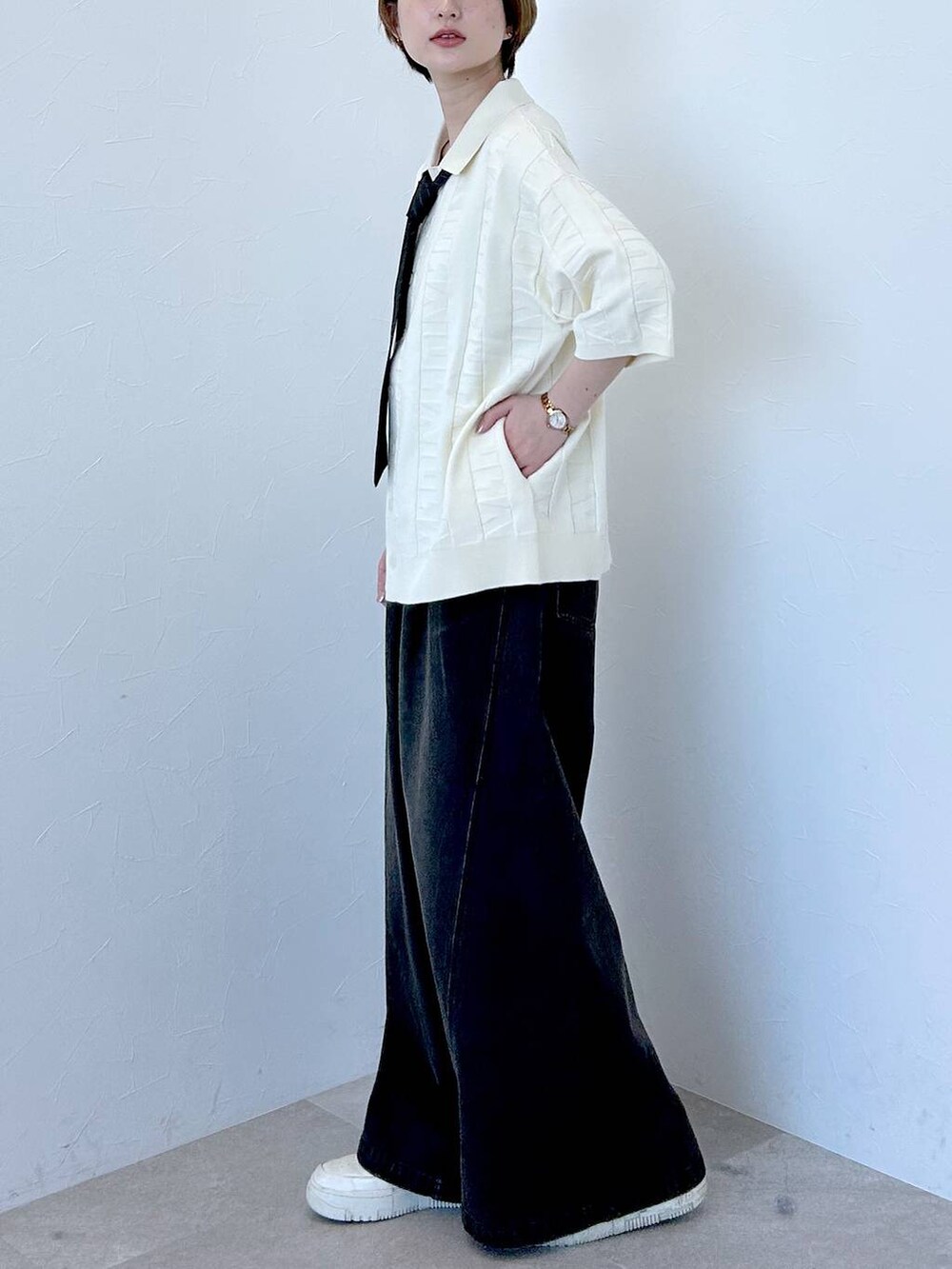 ホワイト系のニット/セーター、ブラック系のデニムパンツ、グレー系のネクタイを着用したレディースの春コーディネートの4枚目の写真