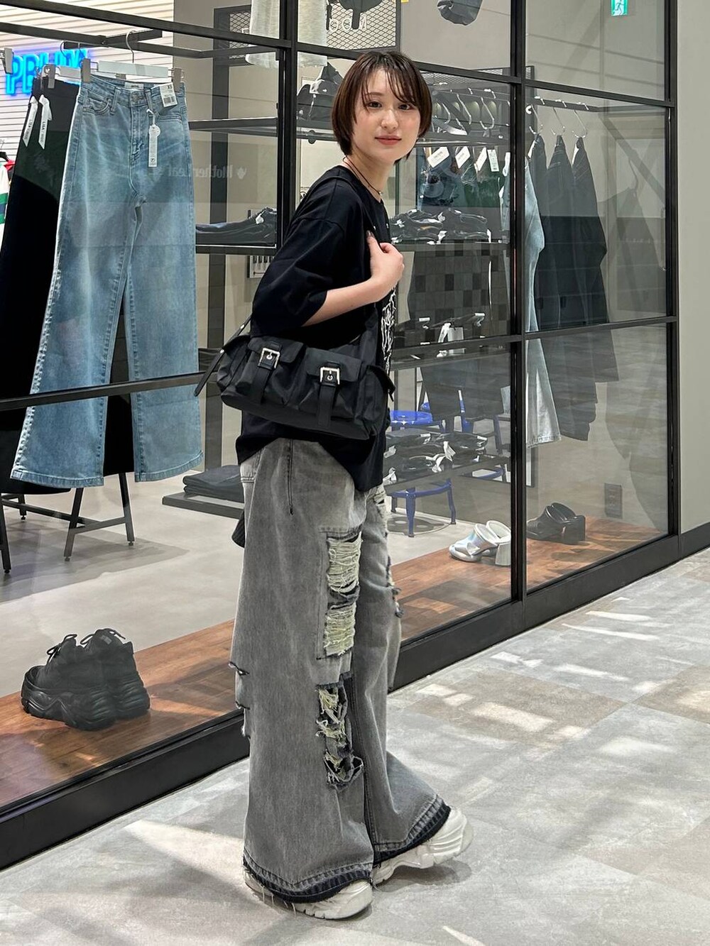 ブラック系のショルダーバッグ、ブラック系のテーラードジャケット、ブラック系のデニムパンツを着用したレディースの春コーディネートの8枚目の写真