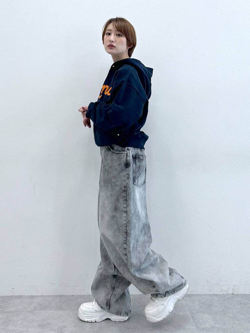 ブルー系のパーカー、ブラック系のデニムパンツを着用したレディースの春コーディネートの4枚目の写真