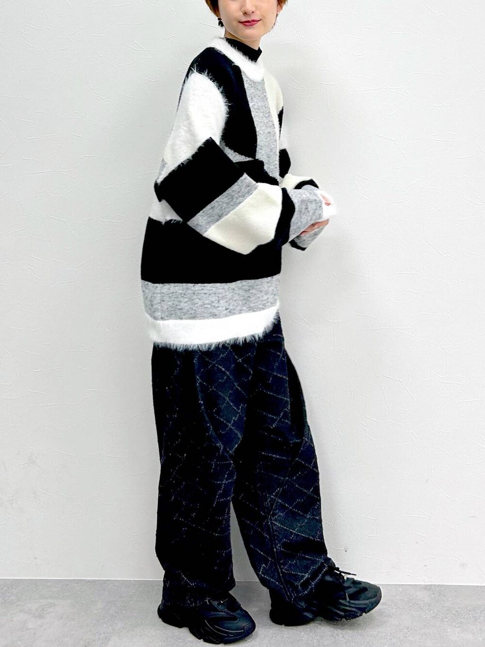 ブラック系のデニムパンツ、グレー系のニット/セーターを着用したレディースの冬コーディネートの6枚目の写真