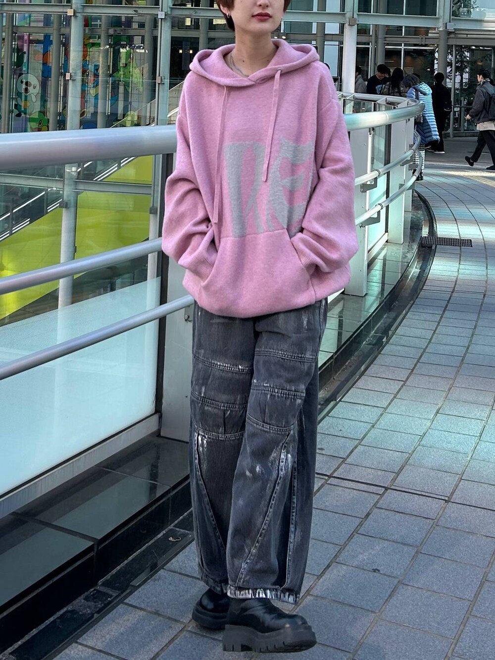 ピンク系のニット/セーター、ブラック系のデニムパンツを着用したレディースの冬コーディネートの2枚目の写真