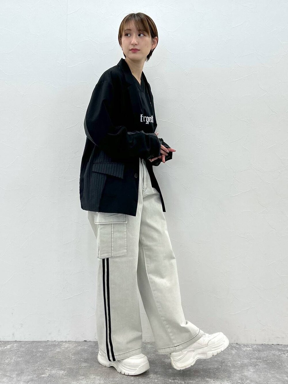 ブラック系のテーラードジャケット、ホワイト系のデニムパンツ、ブラック系のTシャツ/カットソーを着用したレディースの春コーディネートの3枚目の写真