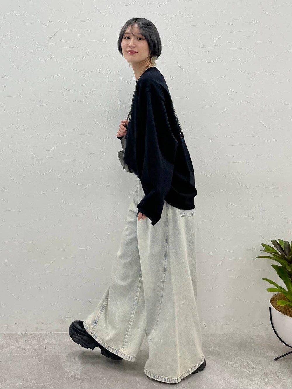 ブラック系のスニーカー、ブルー系のデニムパンツ、その他のショルダーバッグを着用したレディースの春コーディネートの7枚目の写真