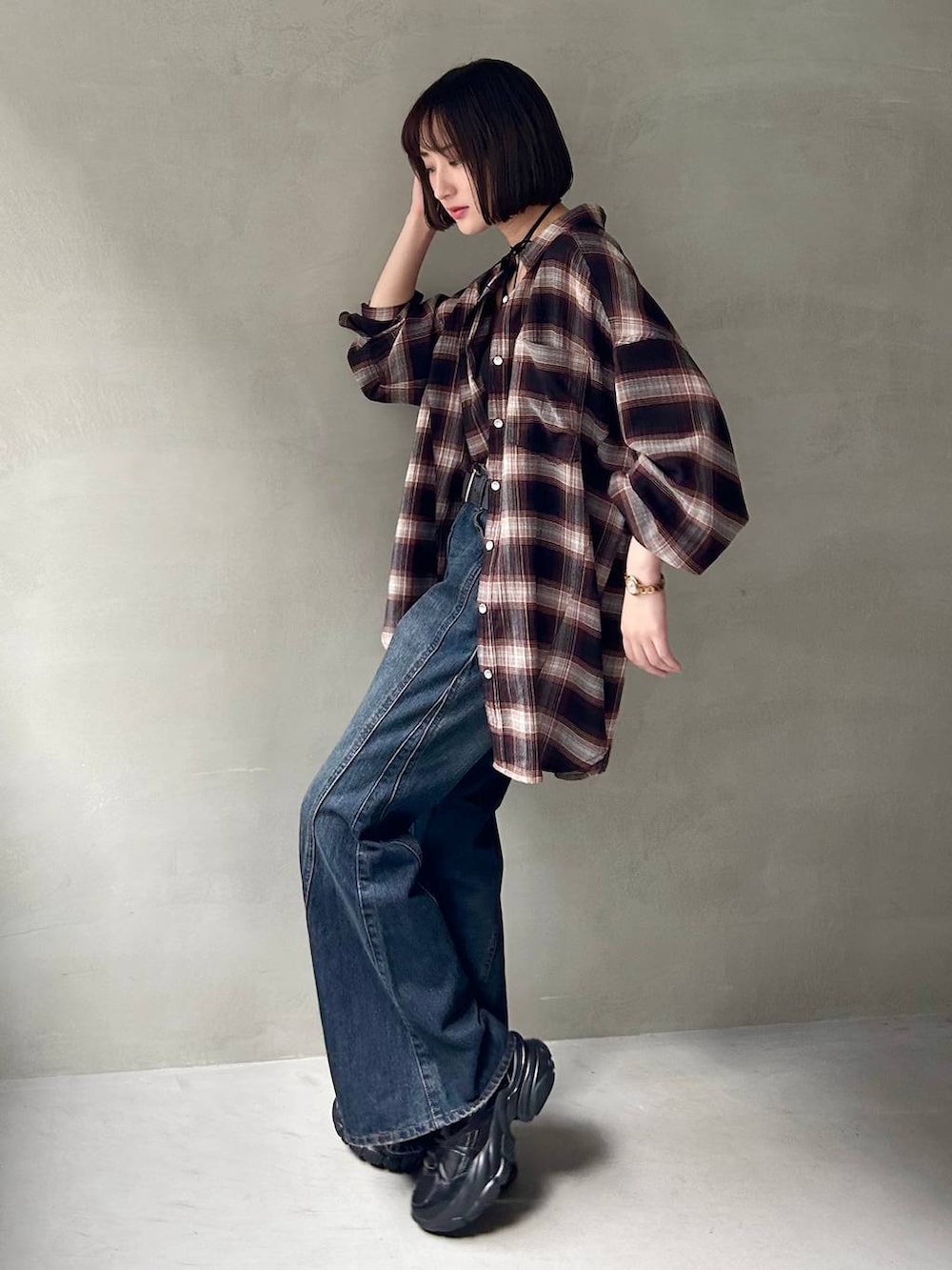 ブラック系のスニーカー、ブラック系のキャミソール、ブルー系のデニムパンツを着用したレディースの夏コーディネートの4枚目の写真