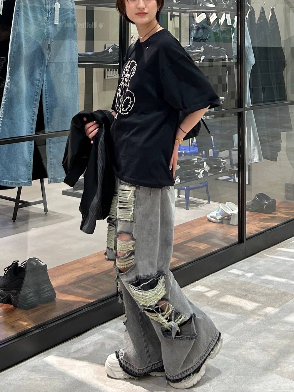 ブラック系のショルダーバッグ、ブラック系のテーラードジャケット、ブラック系のデニムパンツを着用したレディースの春コーディネートの3枚目の写真