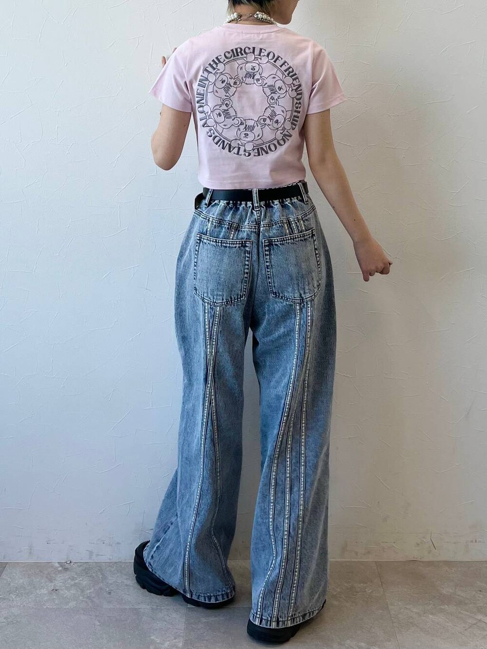 ブラック系のスニーカー、ブラック系のデニムパンツ、ピンク系のTシャツ/カットソーを着用したレディースの春コーディネートの2枚目の写真