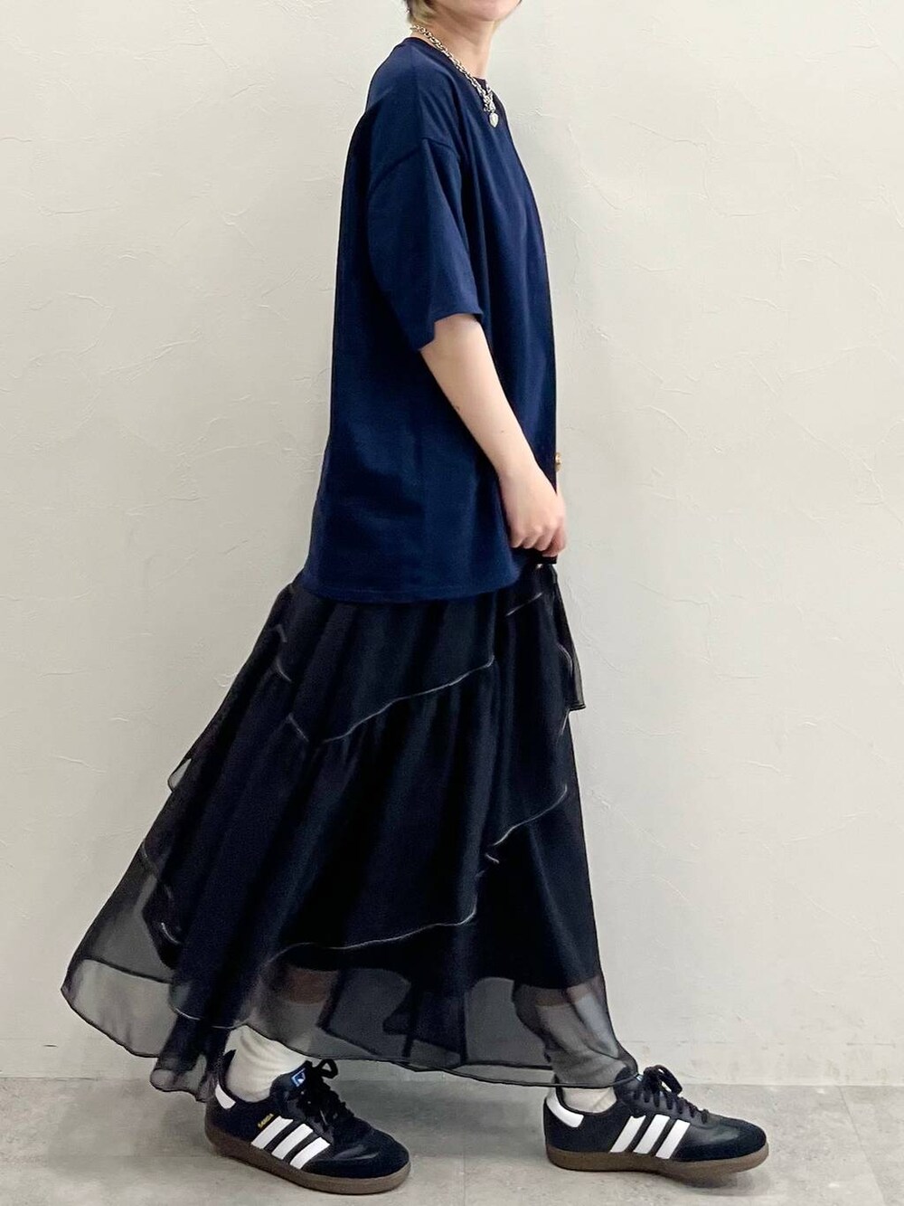 ブラック系のスカート、ブラック系のスニーカー、ブルー系のTシャツ/カットソーを着用したレディースの春コーディネートの6枚目の写真