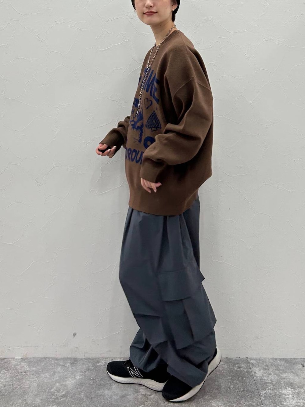 グレー系のカーゴパンツ、ブラウン系のニット/セーター、ブラック系のニットキャップ/ビーニーを着用したレディースの秋コーディネートの4枚目の写真